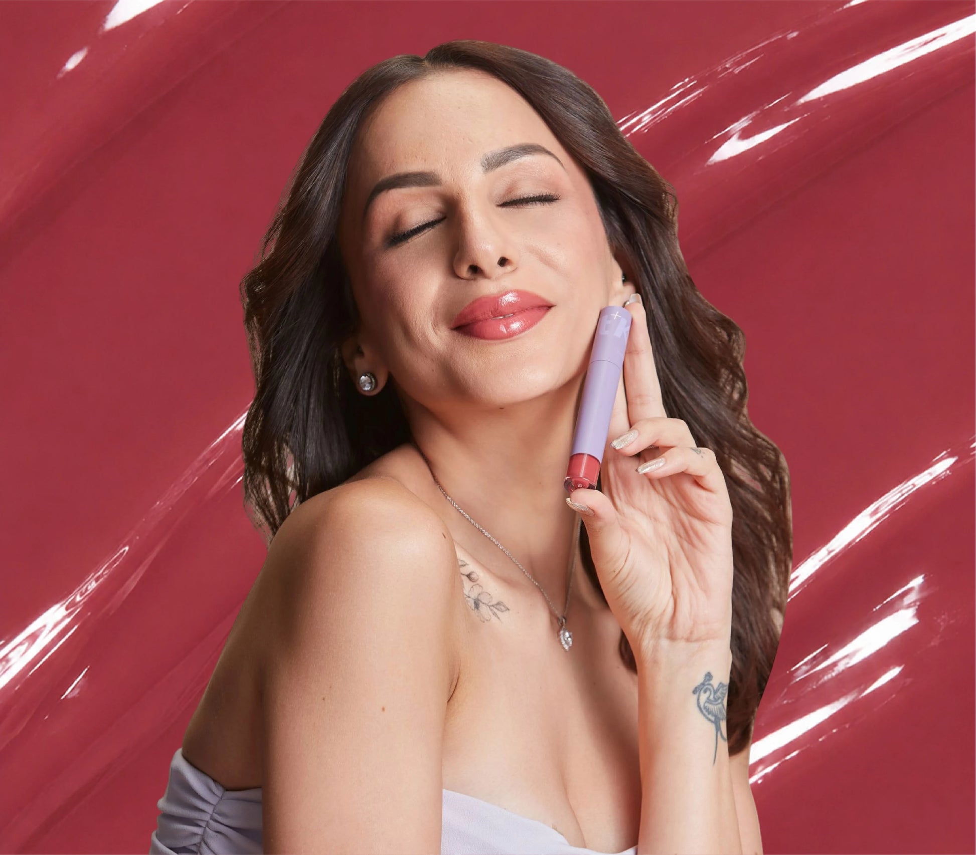 Nitibha Kaul holding ALT+K Beauty Colour Intense Lip Gloss with glossy nude pink lips.