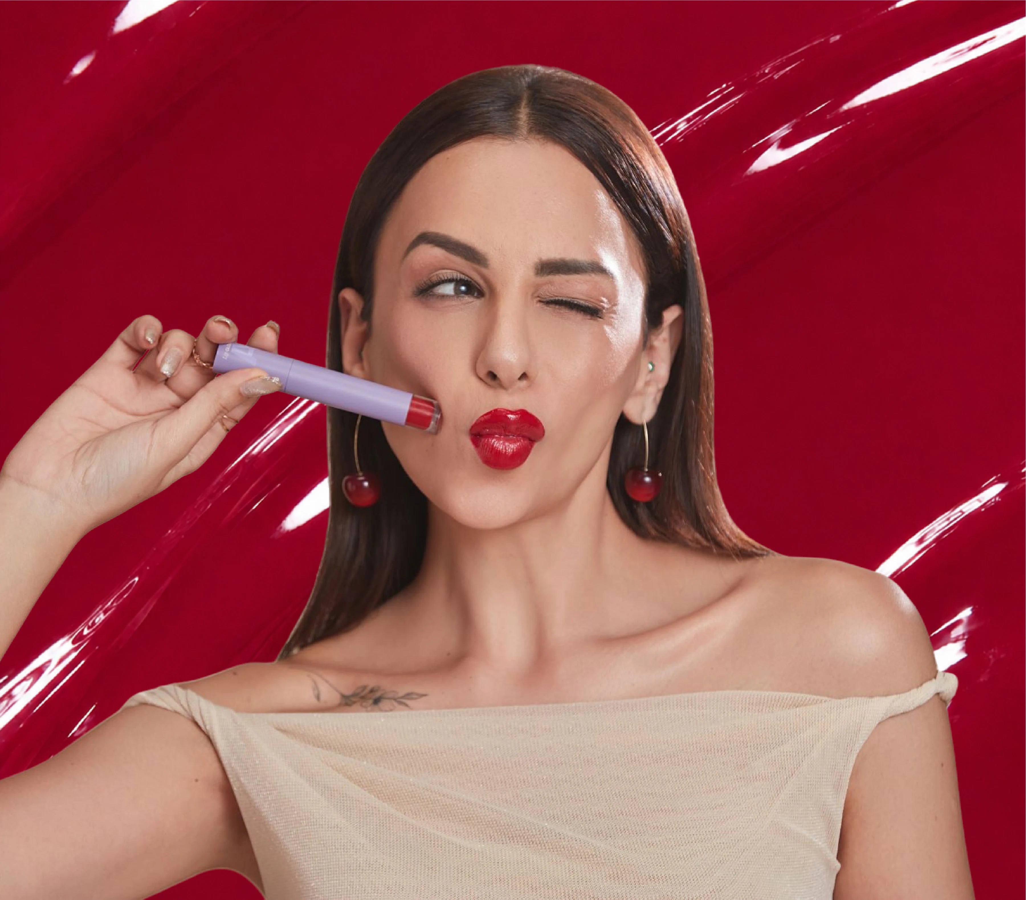 Nitibha Kaul holding ALT+K Beauty Colour Intense Lip Gloss for a high-shine finish.