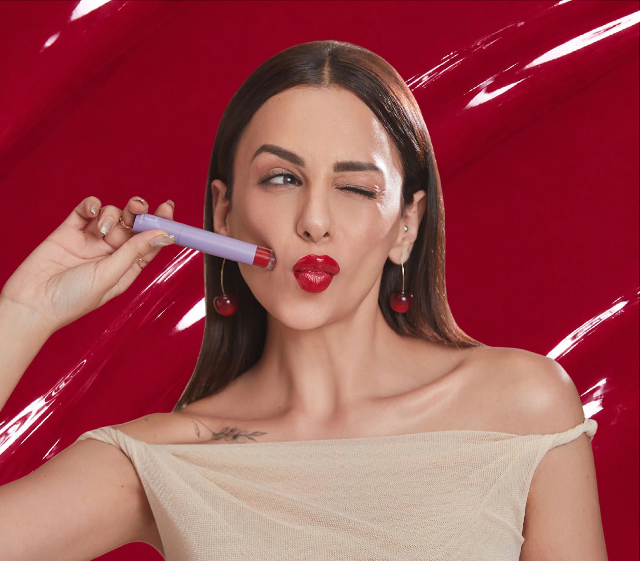 Nitibha Kaul holding ALT+K Beauty Colour Intense Lip Gloss for a high-shine finish.